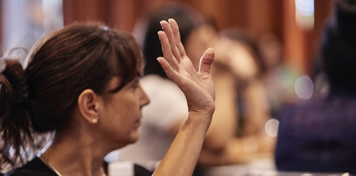 Early childhood educator raises her hand at a conference